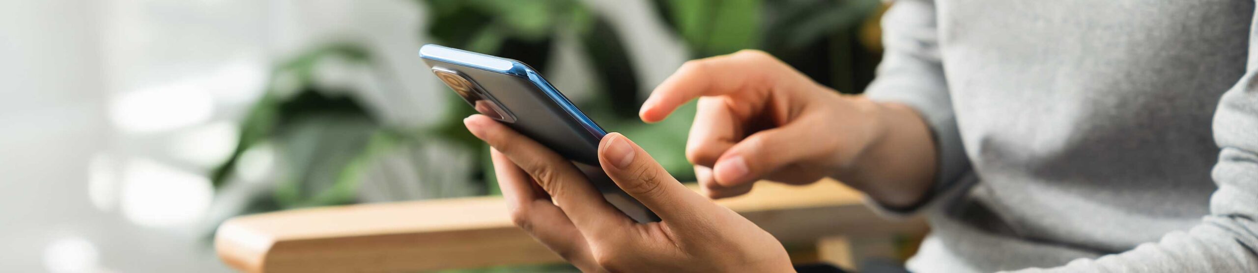 contact-us-slider-image woman sat down using a phone - contact us