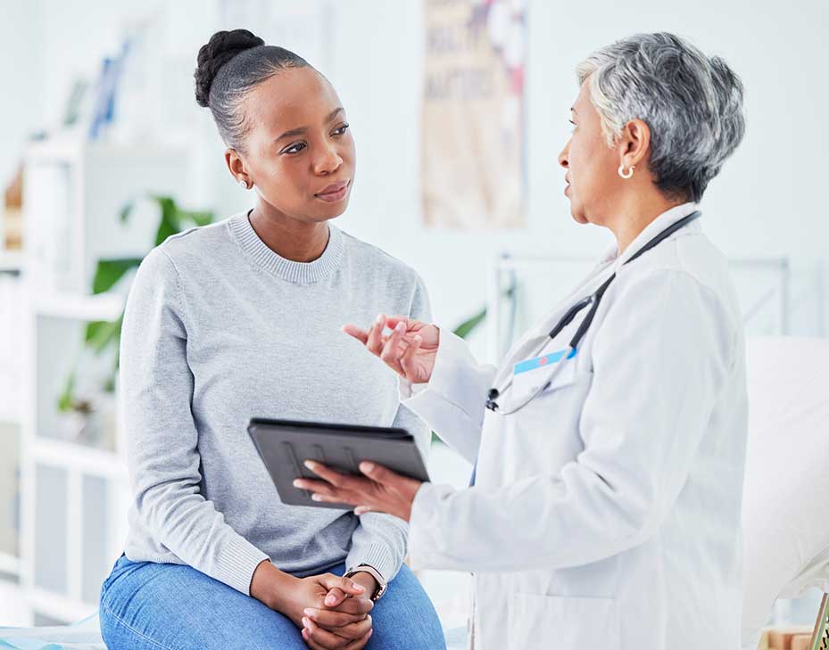 patients-v2 Female Dr talking to a female patient in a bright clean Dr s office
